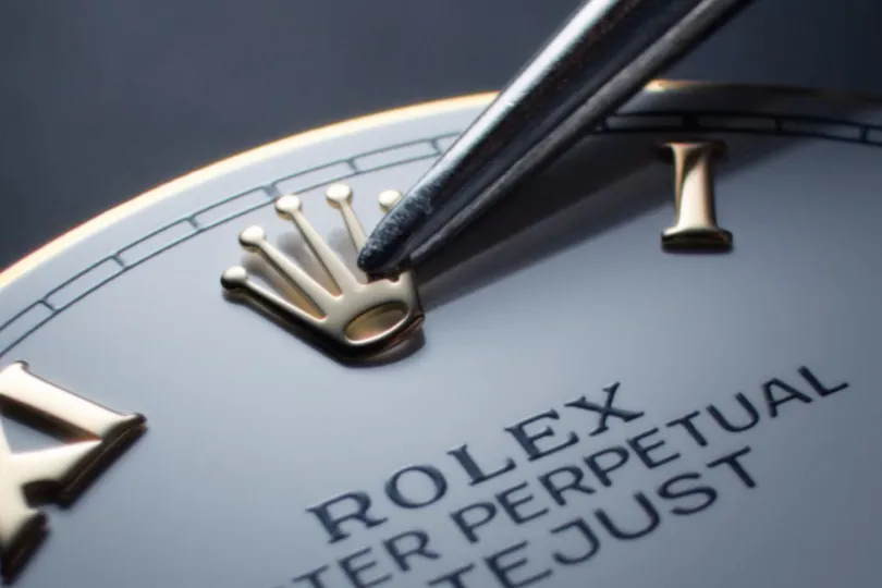 Närbild på urtavla på ett Rolex-ur som håller på att monteras.